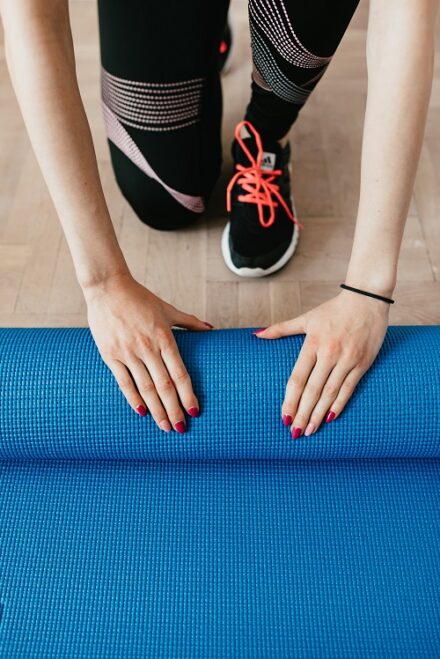 femme en salle de sport avec un tapis de gym