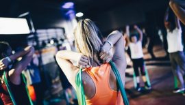 cours de fitness collectif et femme de dos avec un élastique