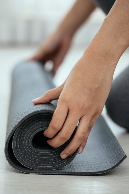 femme en train de dérouler un tapis de gym