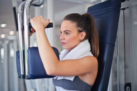 femme en train de muscler ses pectoraux au gym