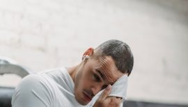 homme sur appareil de musculation s'épongeant le front