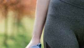 gros plan sur la main d'une femme en legging portant une bouteille d'eau