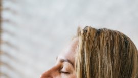 plan serré sur visage de femme joignant ses mains en prière