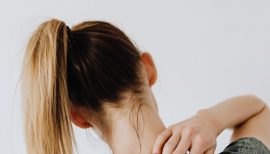 femme en tenue de sport qui se touche le haut du dos