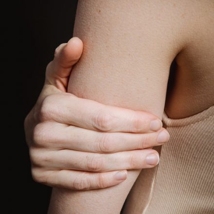 femme se touchant l'arrière du bras triceps mou