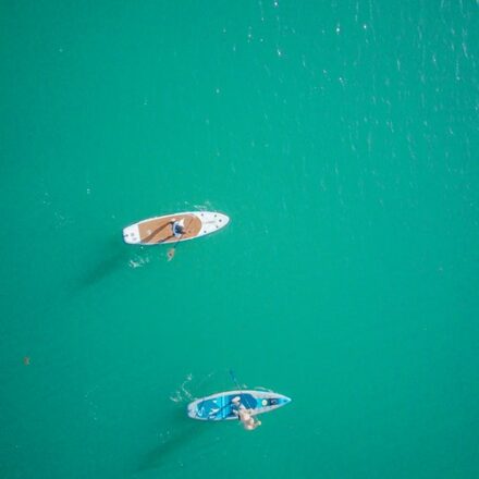 deux paddles vus d'en haut sur une mer émeraude