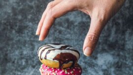 main saisissant un gâteau posé sur une pile de gâteaux