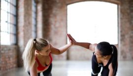 deux femmes faisant la planche au sol et se tapant dans la main