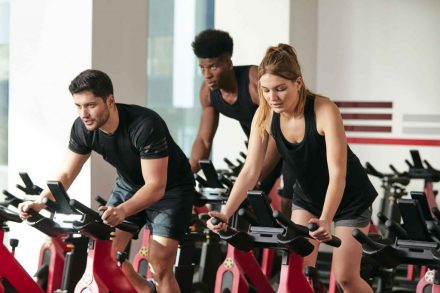 trois pratiquants de sprint sur un vélo indoor