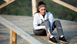 femme au sol victime d'une crampe en plein running