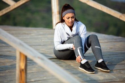 femme au sol victime d'une crampe en plein running