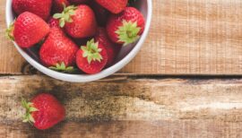 fraises dans un bol posées sur une table de bois