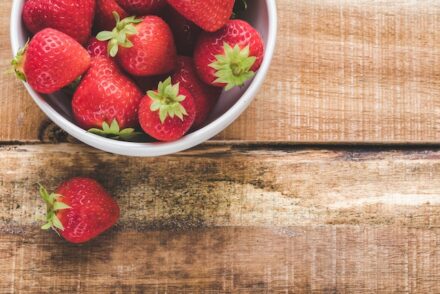 fraises dans un bol posées sur une table de bois