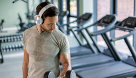 homme soulevant des poids en salle de sport et transpirant