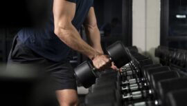 Homme tenant un haltère dans une main pour faire de la musculation