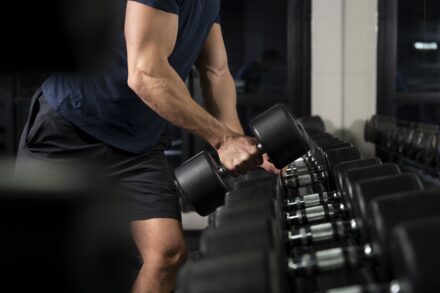 Homme tenant un haltère dans une main pour faire de la musculation