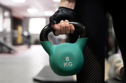 femme tenant un kettlebells pour sa séance en salle de sport