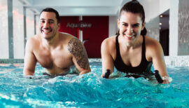 couple dans la piscine d'un club de sport en cours d'aquabike