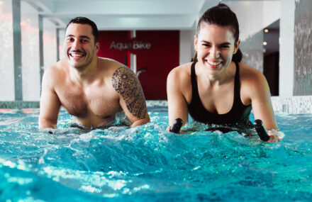 couple dans la piscine d'un club de sport en cours d'aquabike